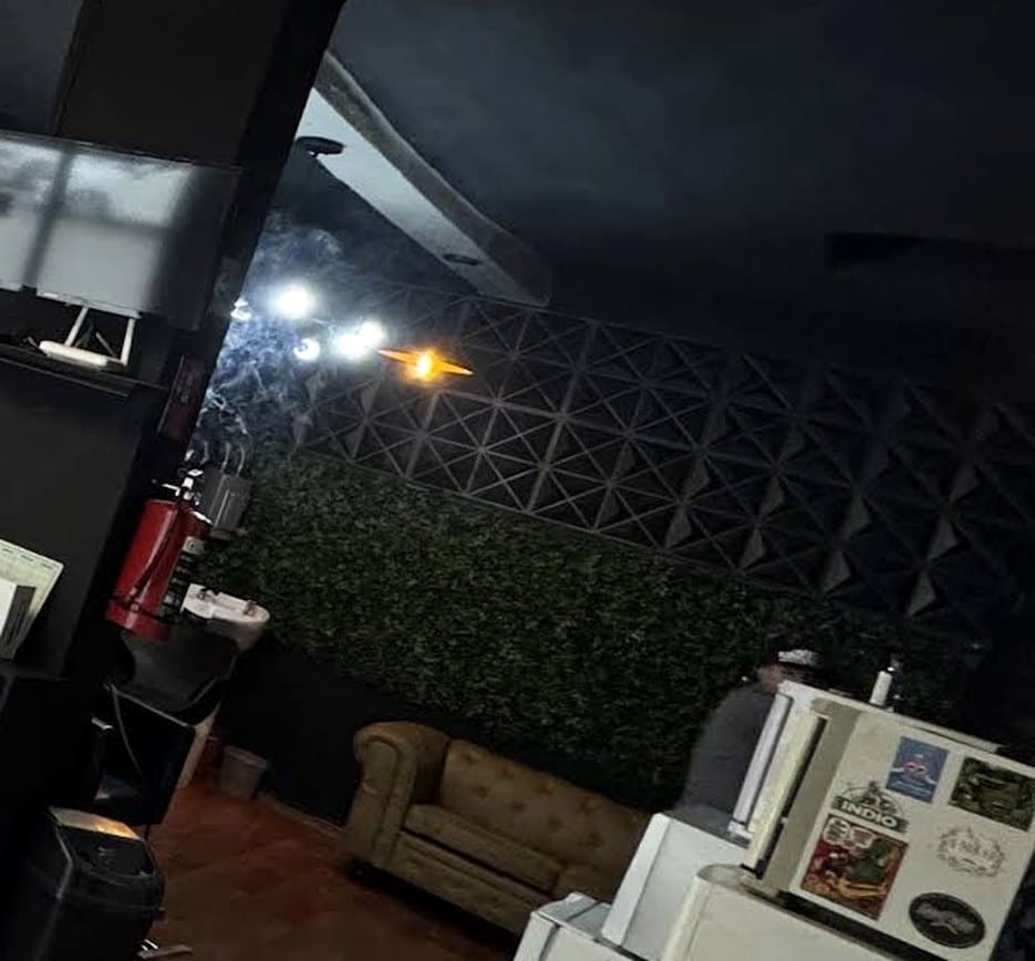 Sala de espera con sillón de piel y muro verde