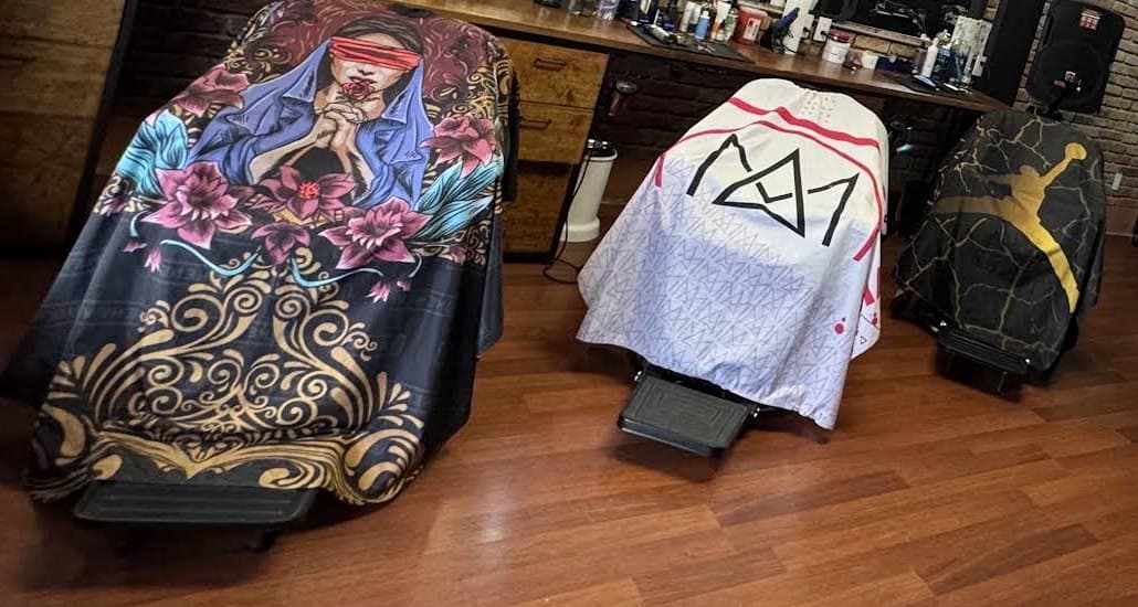 Tres sillas de barbero con capas de colores